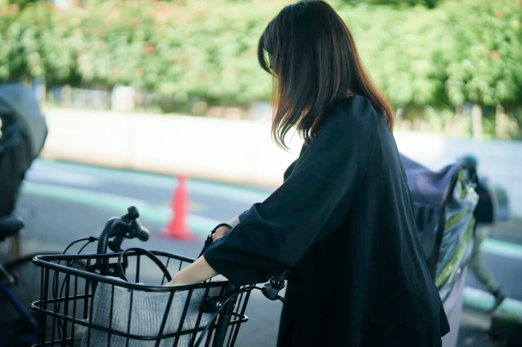 自転車の前かごに荷物を入れる保護者の方