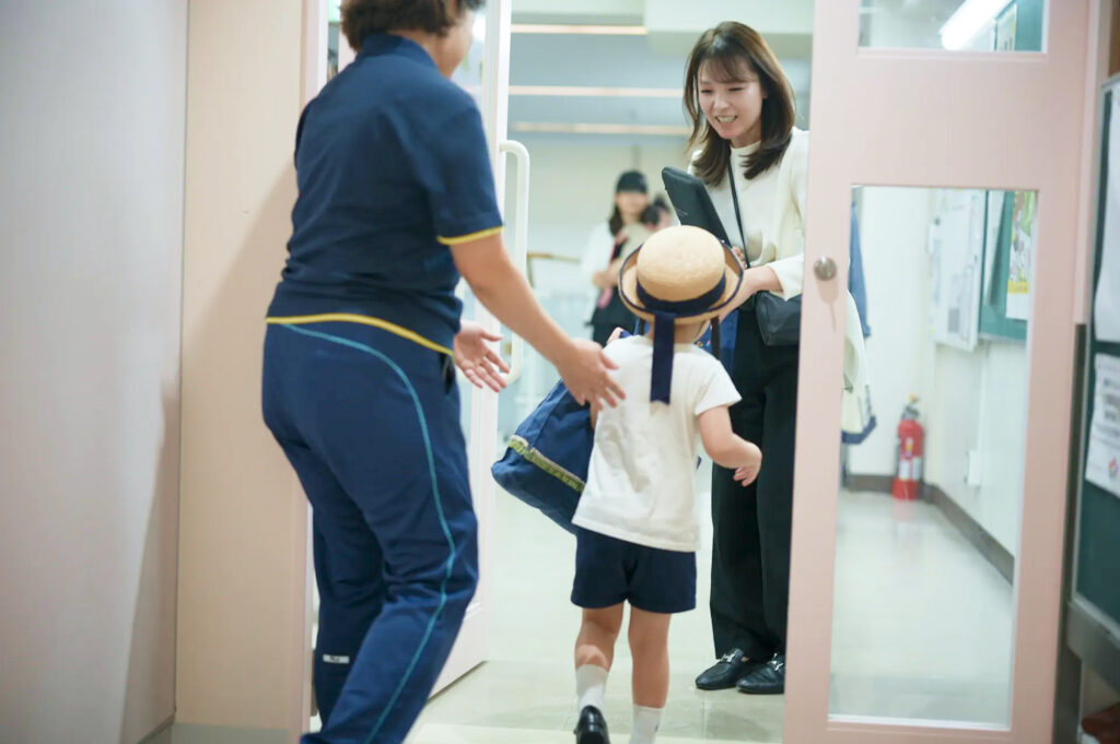 園の入口で子どもと向き合う保護者の方