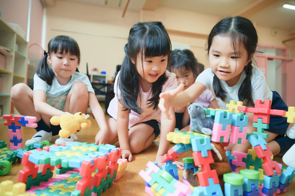 友だちとカラフルなブロックで遊ぶ子どもたち