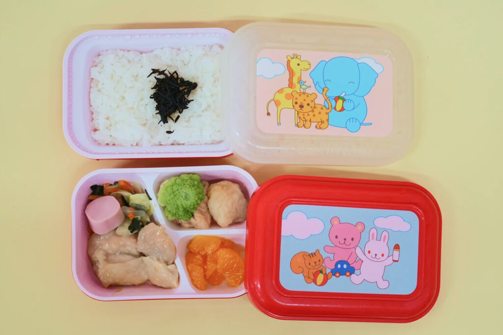 ご飯と複数のおかずが入ったお弁当スタイルの給食